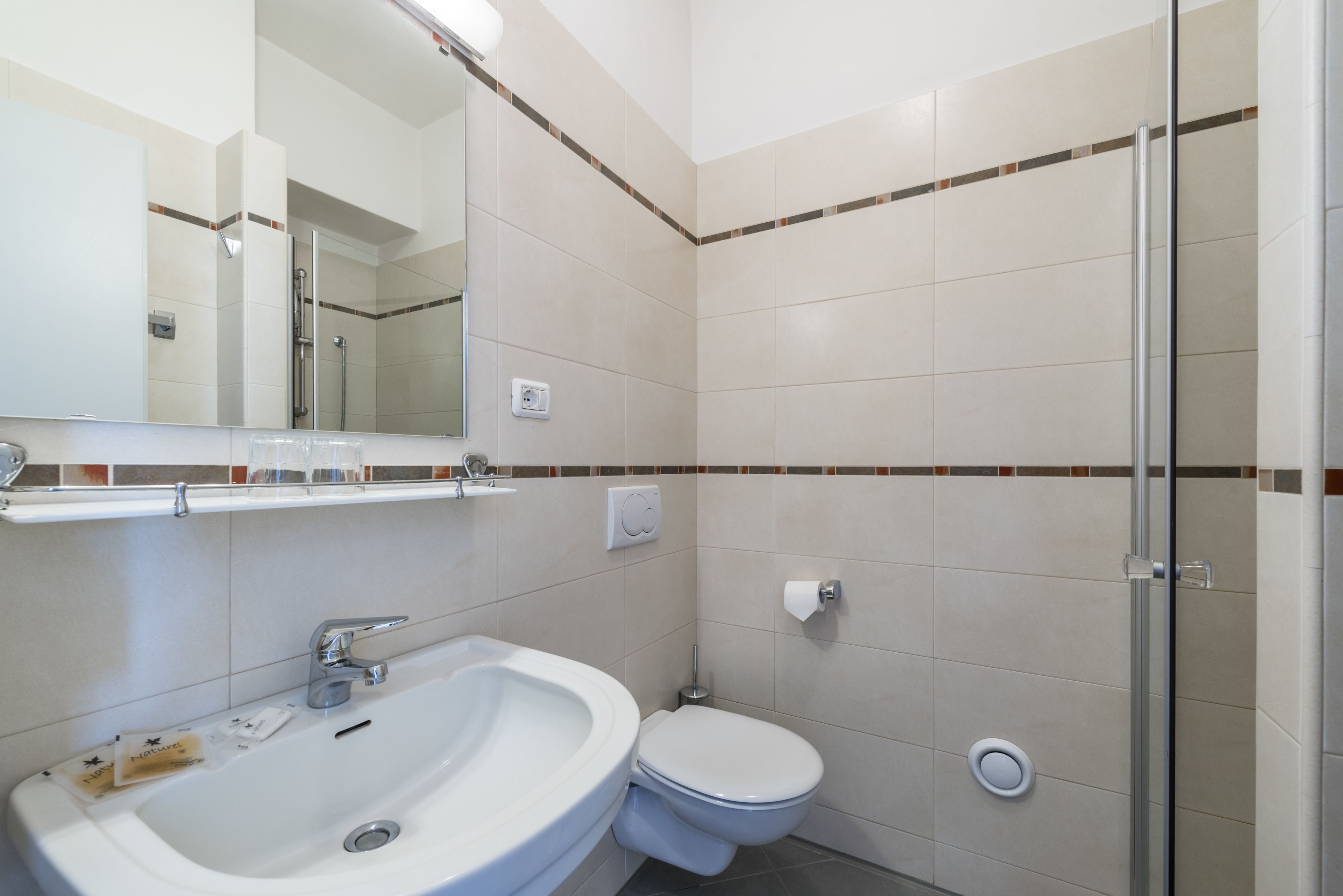 Un baño con lavamanos, inodoro y ducha.