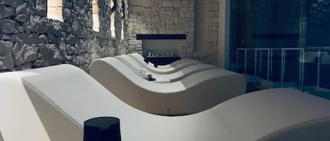 Un interior moderno con pared de piedra y zona de estar curvada.