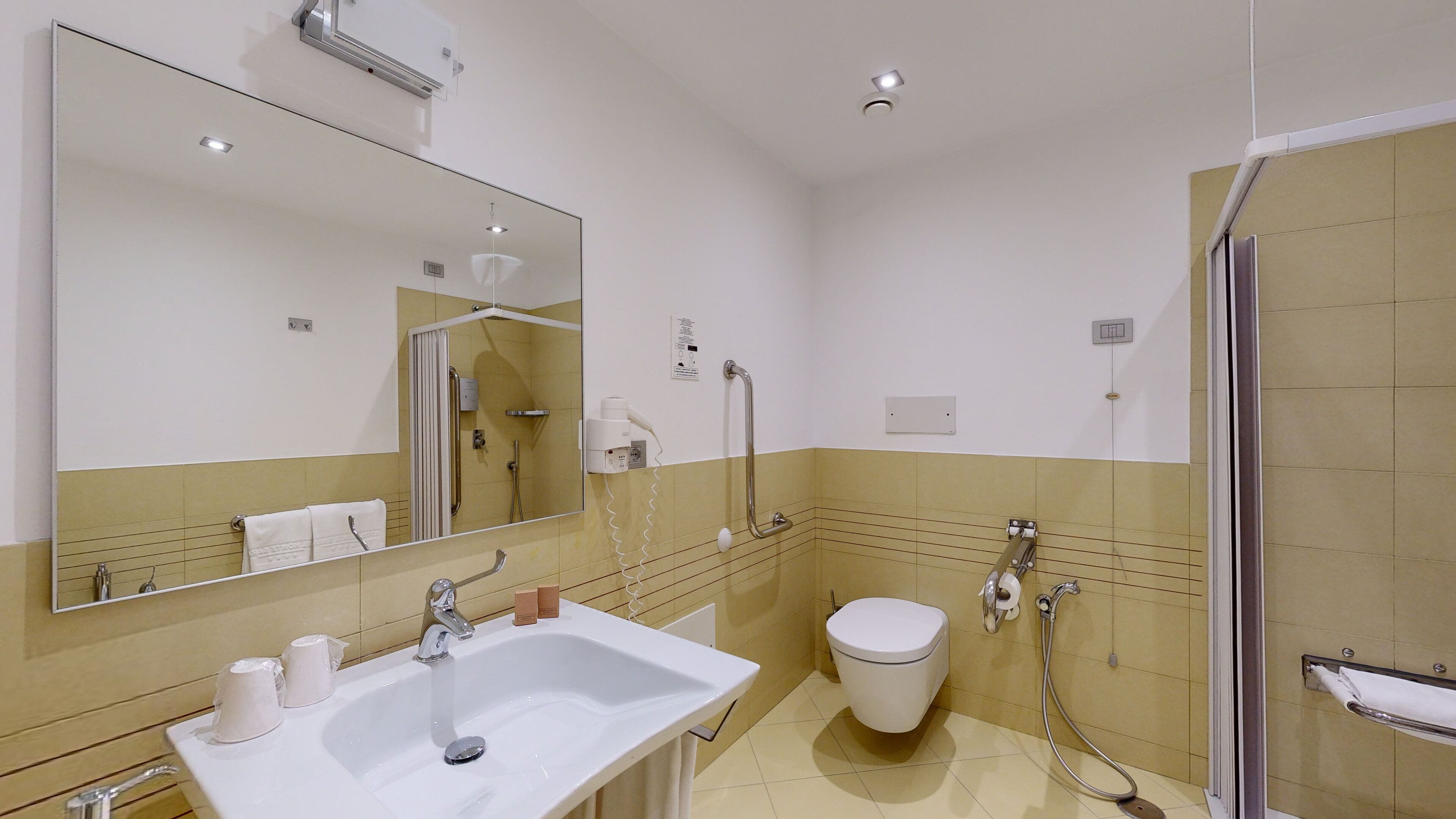 A modern bathroom with a large mirror, a sink, a toilet, and a shower area.