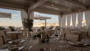 A restaurant with round tables set for dining, featuring white tablecloths, neatly folded napkins, and wine glasses. - Hotel Monte Sarago (Ostuni)