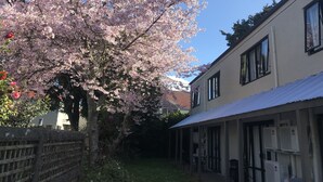 A building with a covered porch and air conditioning units on the exterior wall. - Royal Park Lodge (Auckland)