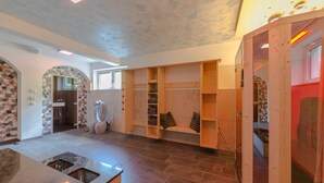 Eine geräumige Küche mit einer Granitarbeitsplatte und einer integrierten Spüle. Holzregale und eine Steinwand mit Mosaikmuster.