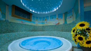 A circular hot tub with mosaic tile walls and a starry ceiling. - Boscone Suite Hotel (Madesimo)