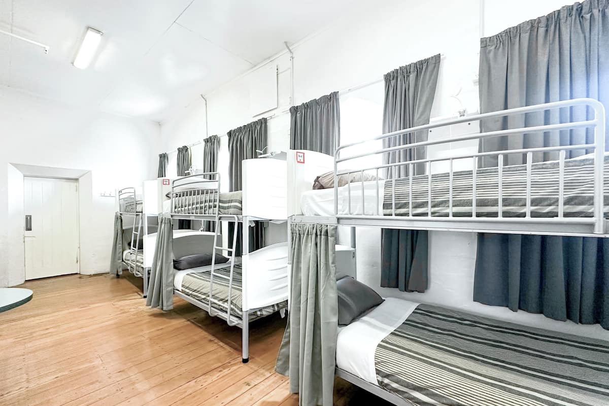 Un dormitorio con literas, una puerta blanca y suelo de madera.