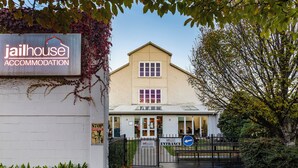 A two-story building with a sign reading 'jailhouse accommodation' and a gated entrance. - Jailhouse Accommodation - Hostel (Christchurch)