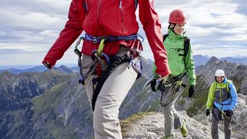 Un paisaje montañoso con excursionistas equipados para actividades al aire libre.