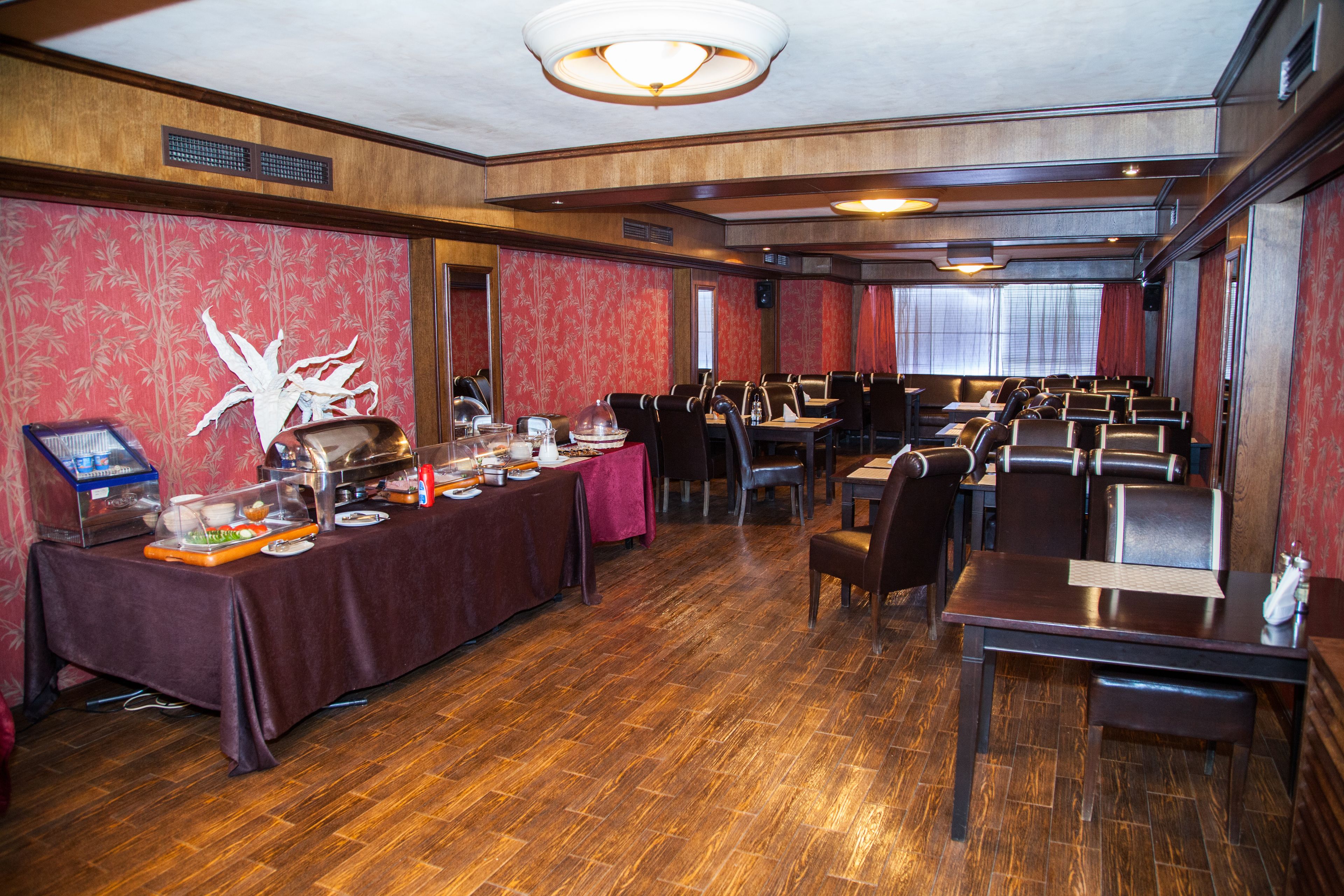 Un espace repas comprenant plusieurs tables et chaises, un buffet et un mur décoratif.