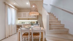 Une cuisine moderne avec des meubles en bois, une table à manger et un escalier.