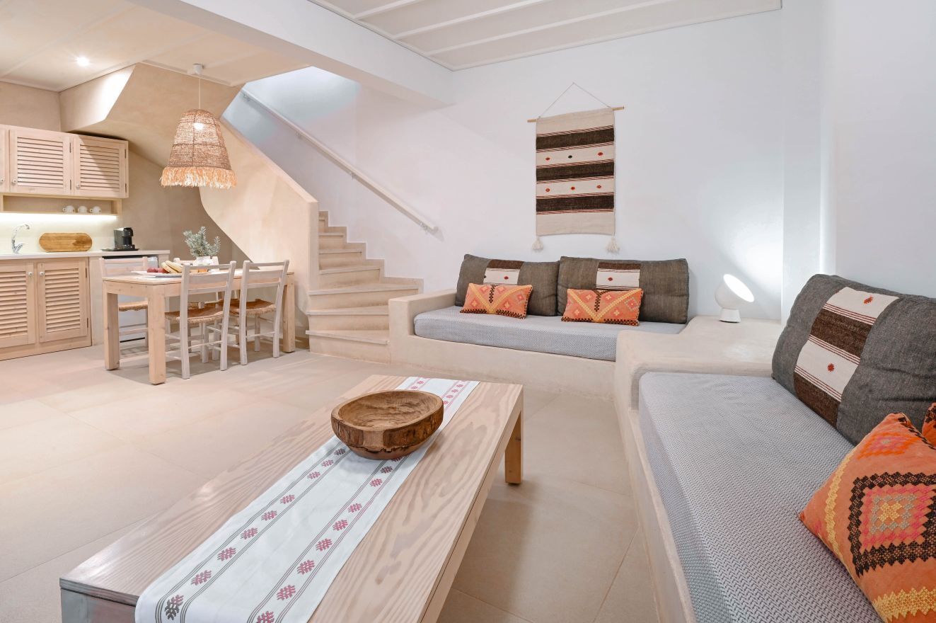 Una sala de estar moderna con una escalera, un comedor y una cocina.