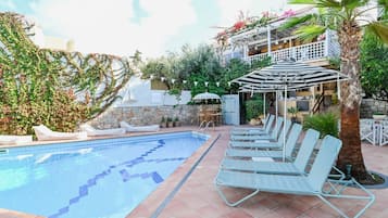 Een buitenzwembad, parasols voor strand/zwembad