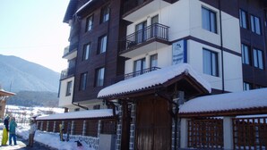 Een hotel met meerdere verdiepingen, balkons en een bord met de tekst 'Mountain Romance'.