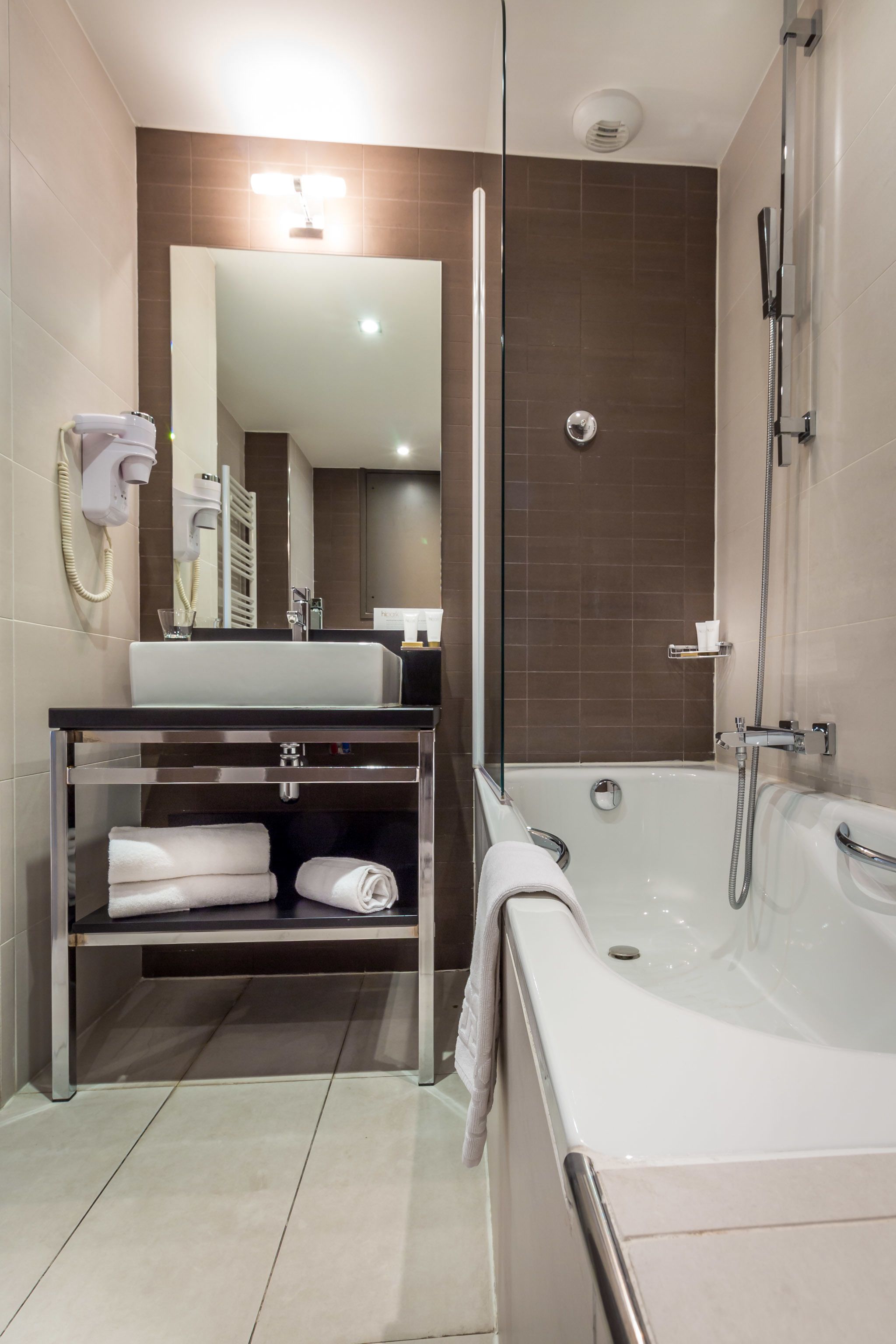 Een moderne badkamer met een bad, een wastafel en een spiegel.