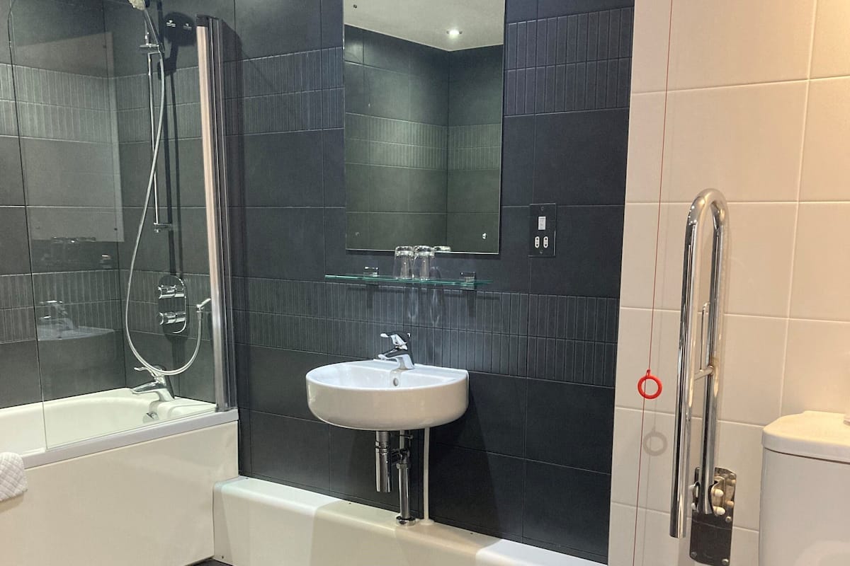 A modern bathroom with a bathtub, a sink, and a toilet.