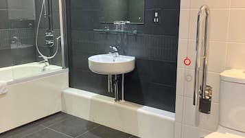 A modern bathroom with a bathtub, a sink, and a toilet.