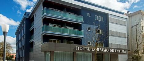 A modern hotel building with a sign reading "HOTEL CORAÇÃO DE FÁTIMA."