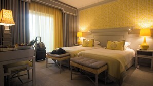 Habitación de hotel con dos camas, un escritorio y una silla.