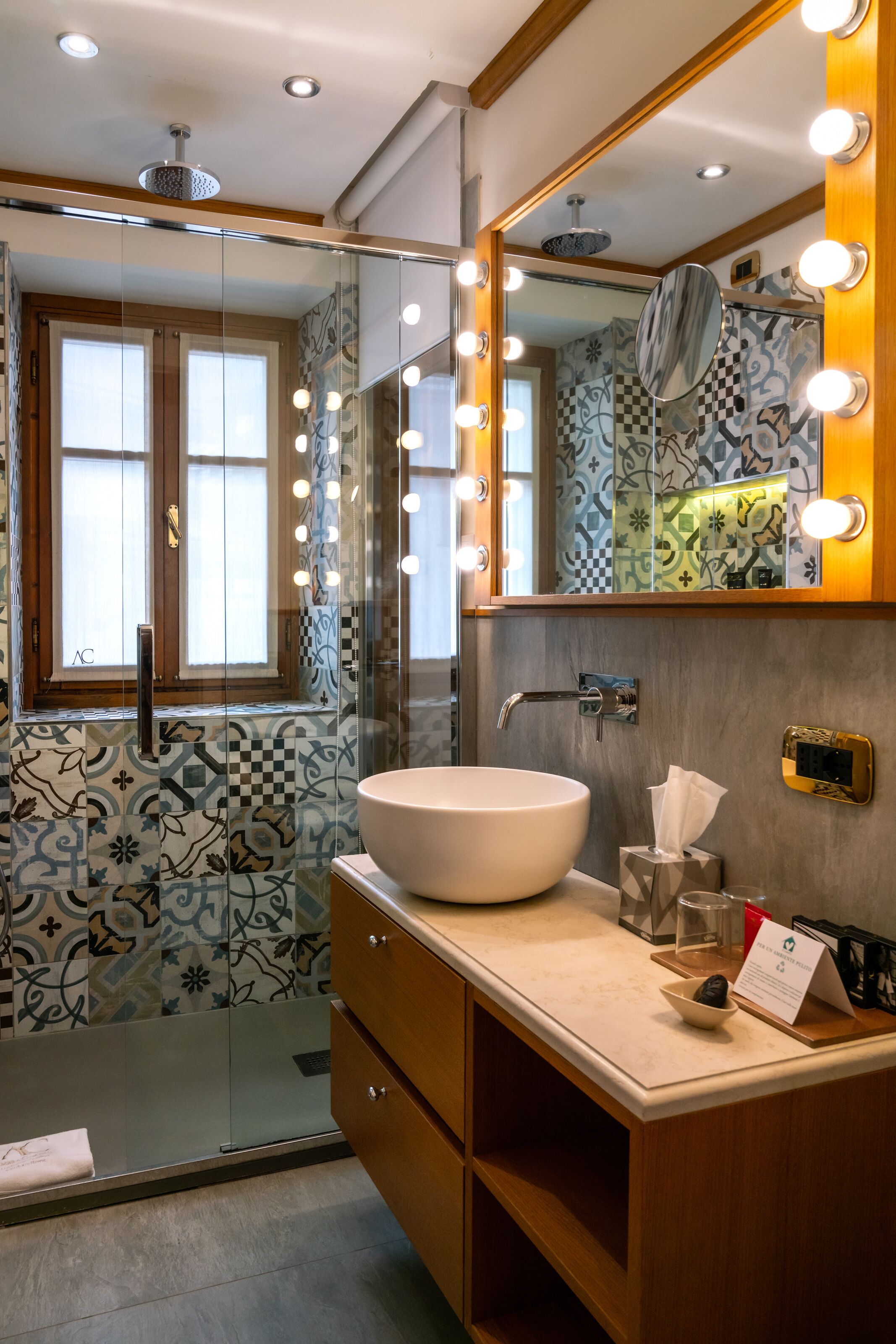 Un baño con un espejo grande, tocador y zona de ducha.