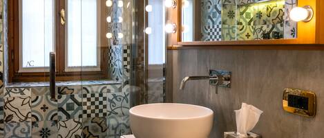 Un baño con un espejo grande, tocador y zona de ducha.