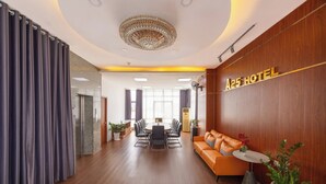 A modern hotel lobby with a round table, a sofa, and a chandelier. - A25 Premium Hotel - 29 Bui Thi Xuan (Ho Chi Minh City)