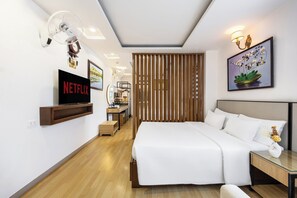 A modern hotel room with a large bed, a TV mounted on the wall, a wooden partition, and a framed artwork above the bed. - A25 Premium Hotel - 29 Bui Thi Xuan (Ho Chi Minh City)
