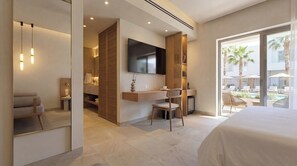 Una habitación de hotel moderna con una cama grande, un escritorio con una silla, un televisor y vistas a la piscina y palmeras afuera.