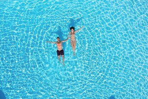 Vue aérienne d’une piscine où flottent deux personnes.