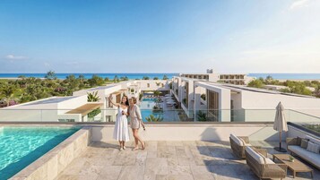 Un moderno resort con piscina, mobiliario exterior y vistas al océano.