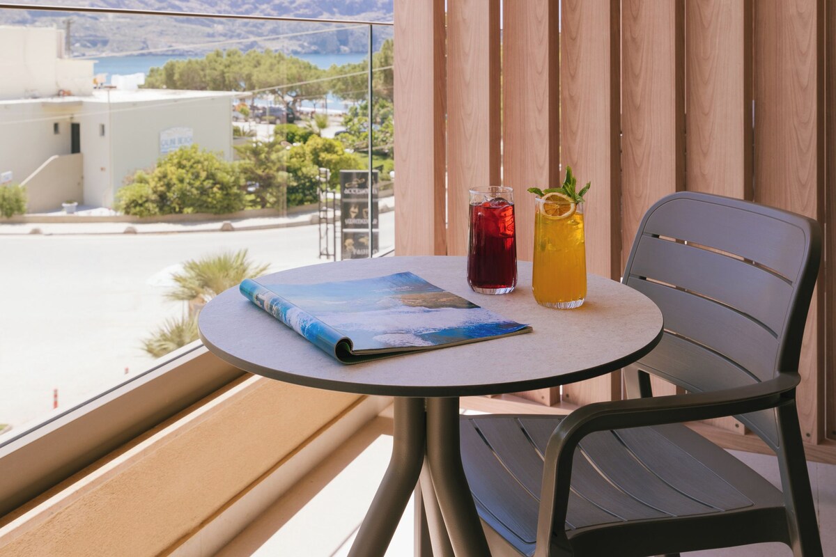 A balcony with a table, two drinks, and a book.