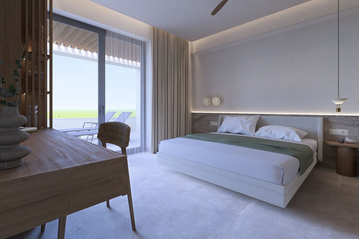 Et moderne hotelværelse med en stor seng, et træskrivebord og en balkon med udsigt.