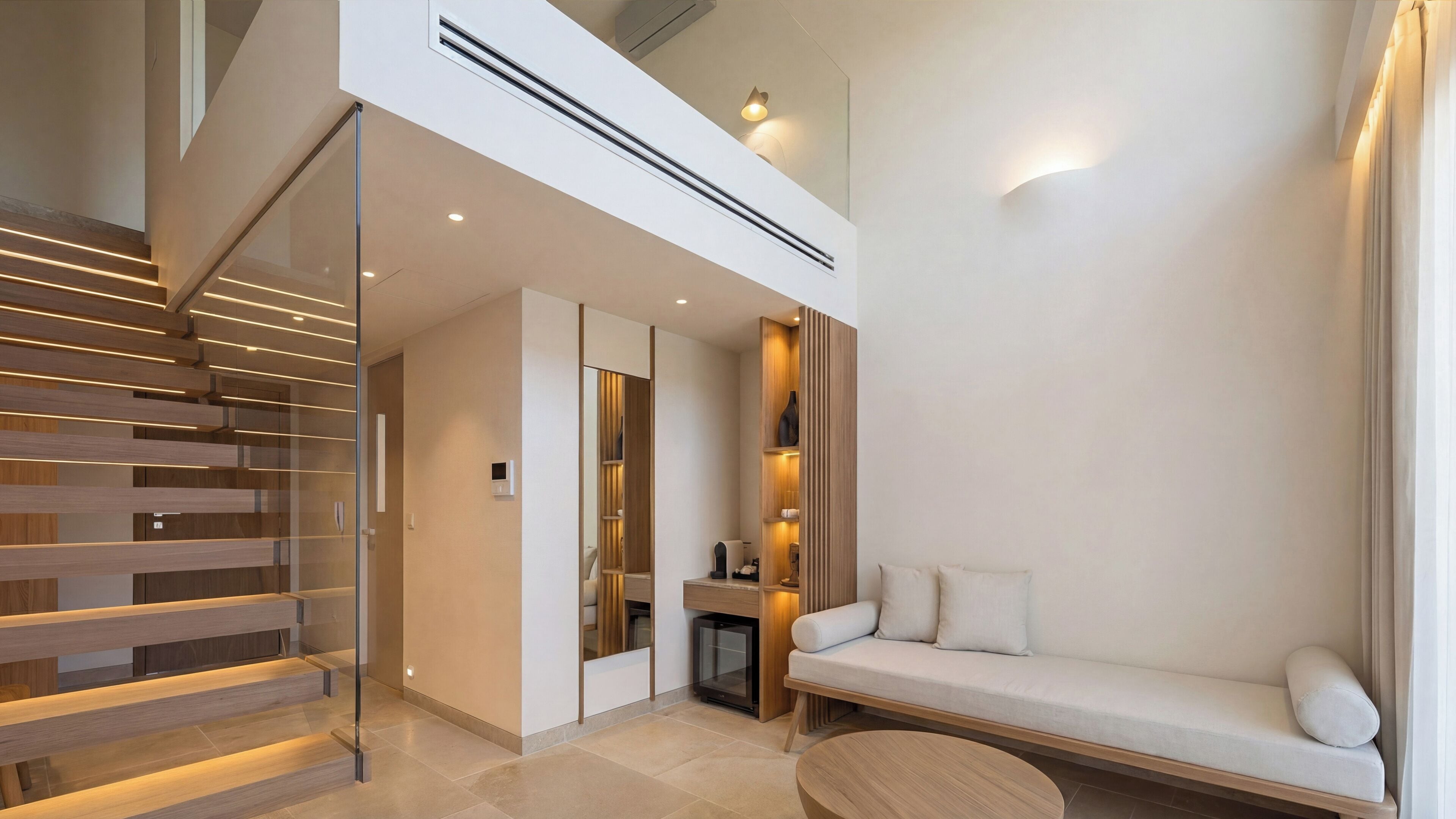 Una sala de estar moderna con una escalera, un sofá y una mesa de centro.