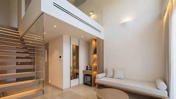 Una sala de estar moderna con una escalera, un sofá y una mesa de centro.