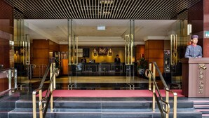 A hotel lobby with a reception desk, a red carpeted staircase, and a modern interior design. - Hotel Riverview Taipei (Taipei)