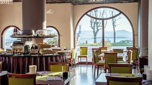 Un restaurante con vistas a las montañas, un bufé con diversas opciones de comida y una máquina de café.