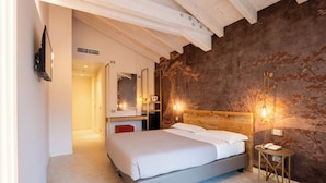 Un dormitorio con cama, mesita de noche, espejo y pared con diseño texturizado.
