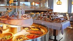 A buffet setup with various dishes and a central serving area. - Panoramahotel Post (Bressanone)