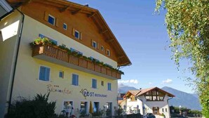 A two-story building with a restaurant named "POST Restaurant" on the ground floor. - Panoramahotel Post (Bressanone)