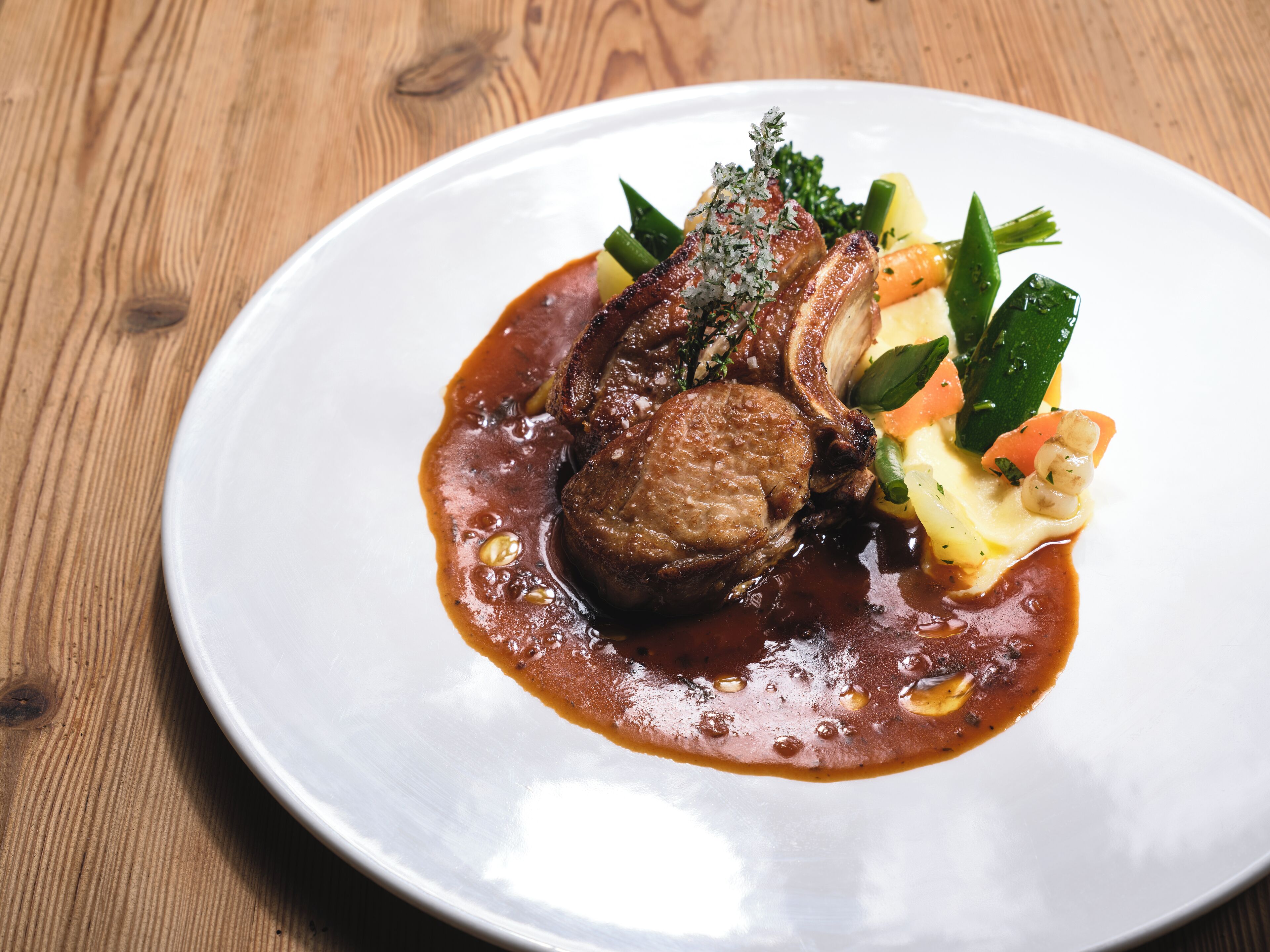 Un plato de comida con un guiso de carne, verduras y salsa.