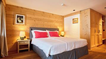 Un dormitorio con paneles de madera, una cama, mesitas de noche y un armario.
