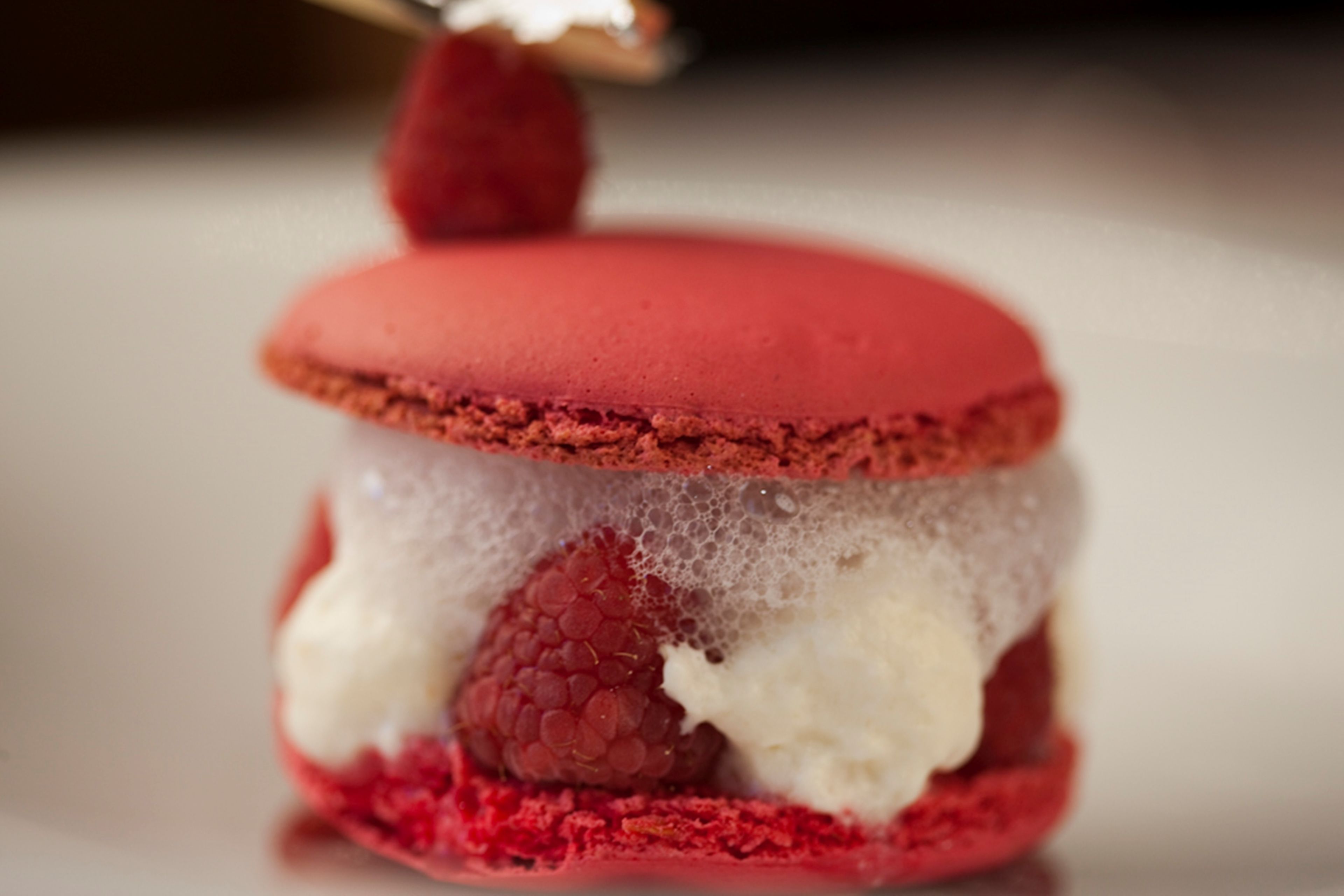 Un dessert con una lampone sopra.