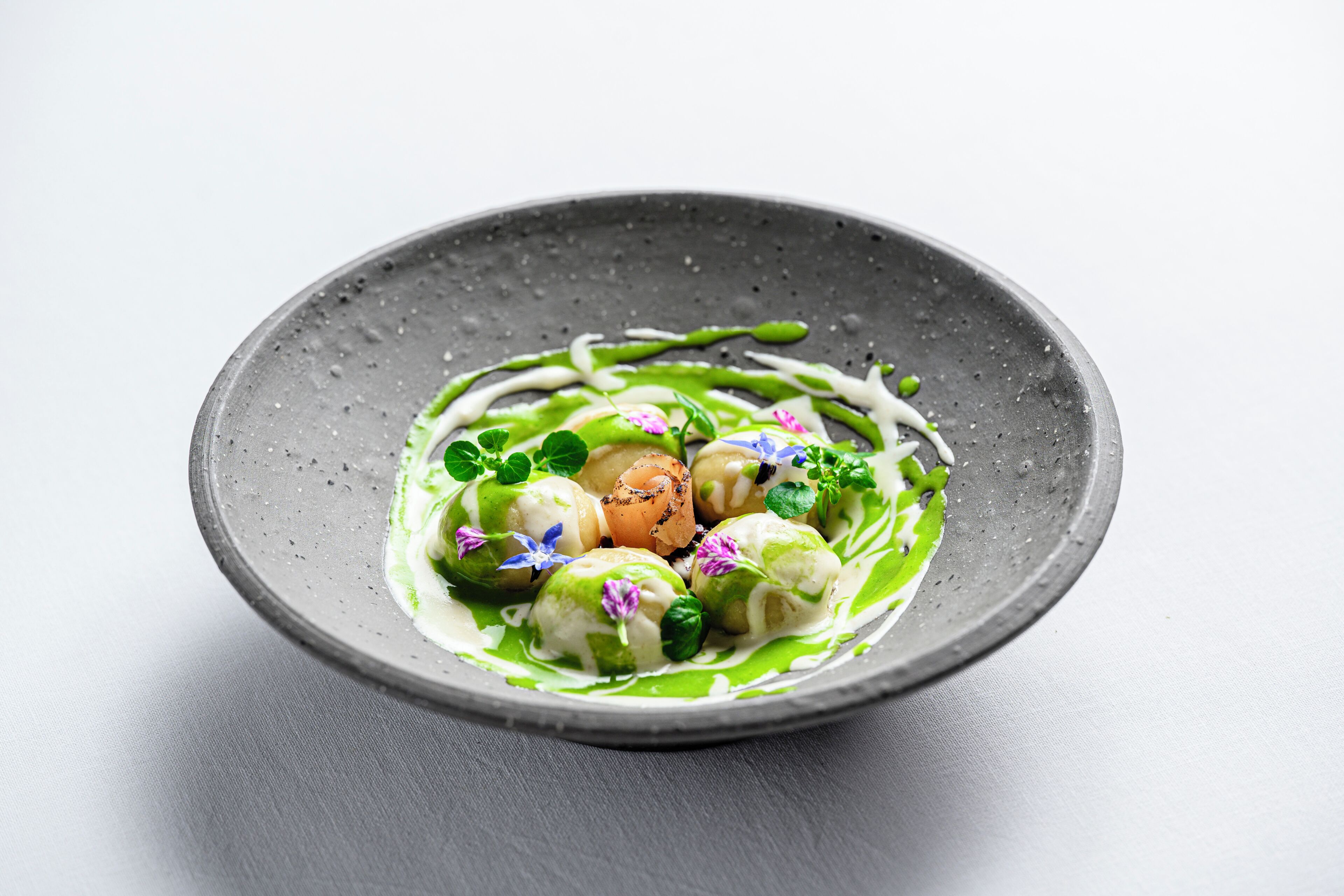 Un plato de comida con salsa verde y adornos.