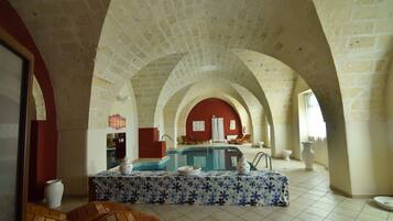 Relax in a spacious room with a pool table, comfortable seating areas, and classic architecture.