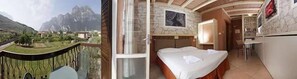 Une chambre avec un lit, une petite table et une vue sur les montagnes.