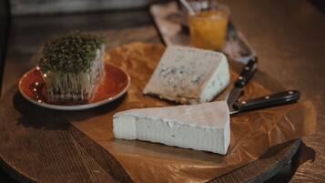 Une assiette de fromages variés et un couteau, le tout posé sur une table en bois.