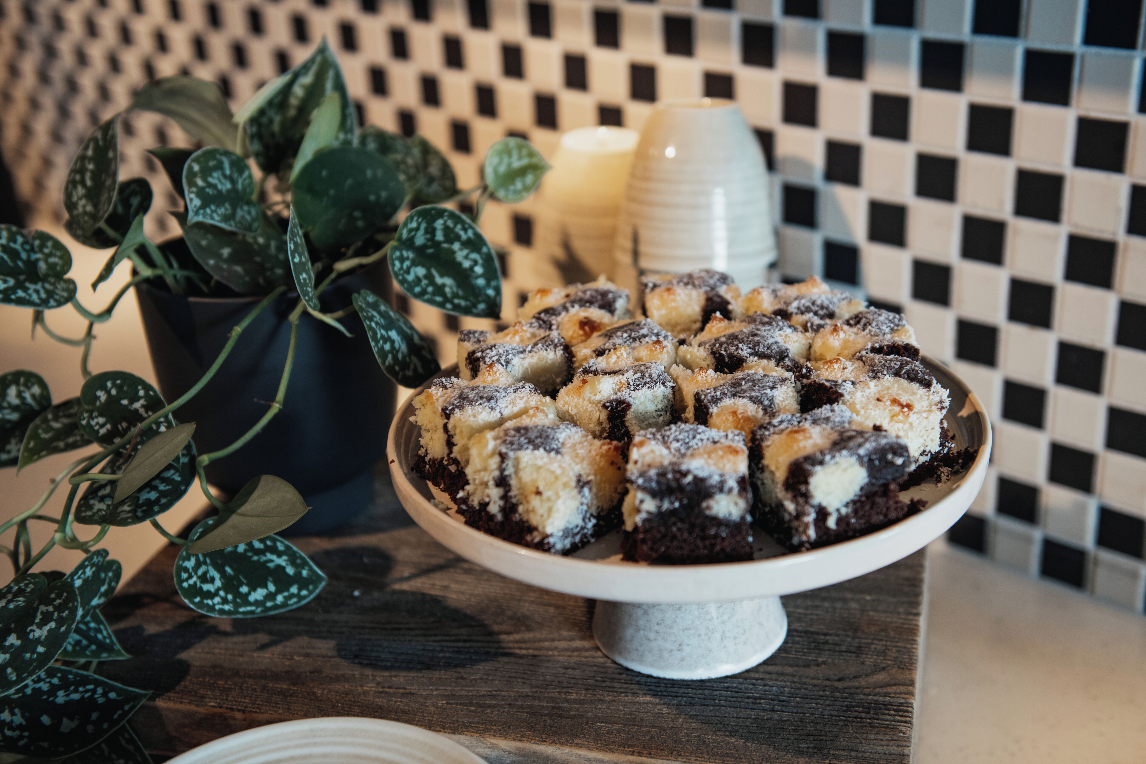 A dessert plate with a checkered tile wall in the background.