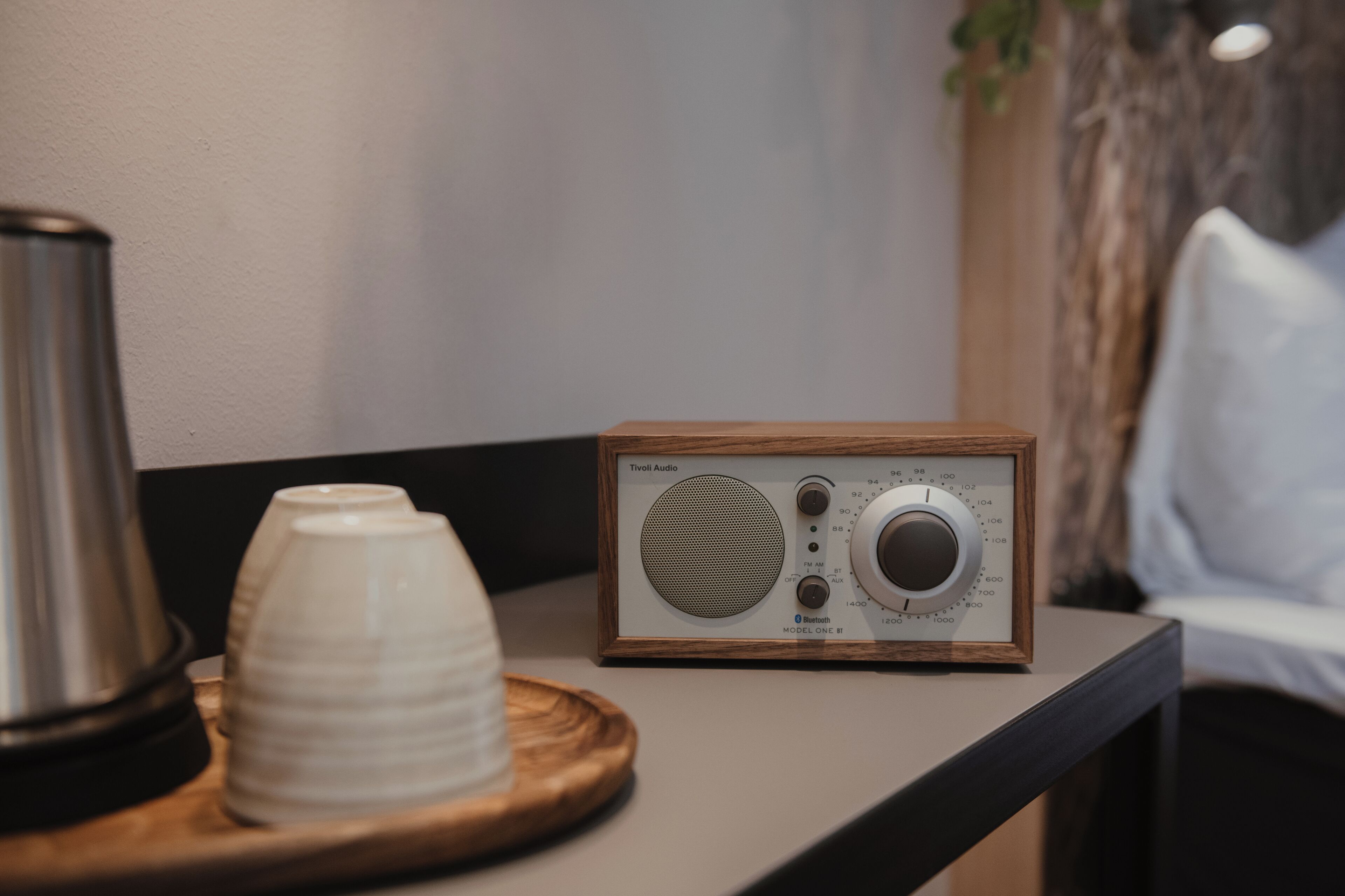Una radio de madera sobre una mesa, junto a una taza y un platillo.