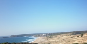 Un paisaje costero con playa, acantilados y cielo despejado.