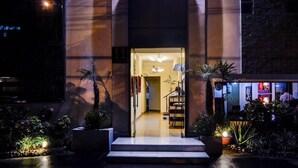 A hotel entrance with a staircase leading inside, potted plants, and a well-lit interior. - Hotel Ferre De Ville (Lima)