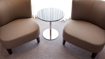 Twee fauteuils tegenover elkaar met een kleine ronde tafel ertussen.