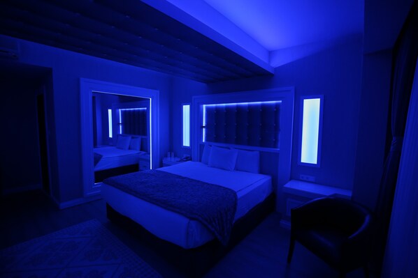 A modern bedroom with a large bed, bedside tables, and a chair. - Seckin Hotel (Erenler)