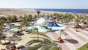 A resort pool area with lounge chairs, umbrellas, and a water slide. -  Three Corners Sea Beach Resort (El Quseir)